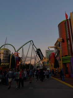 people walking around an amusement park at dusk