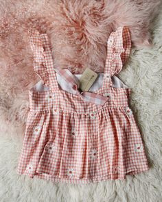 A soft orange gingham check base pairs with the cutest daisy embroidery & ruffle sleeves. Fully lined bust with a soft fluttery fit. Color: Orange & white Cotton blend Hand wash cold Small Medium Large Bust 35 37 39 Waist 34 36 37 Hips 39 40 41 Length 22 22 23 Bust, waist, and hip measurements are a total circumference. Length is measured from the top of the blouse to the hem. Measurements are an estimate. Cute Daisy Print Tops For Spring, Spring Gingham Sleeveless Top, Sleeveless Gingham Top For Spring, Cute Spring Tops With Ruffle Hem, Summer Cottagecore Tops With Ruffles, Cute Fitted Tops For Picnic, Cotton Top For Spring Picnic, Summer Cottagecore Ruffled Tops, Feminine Gingham Tops For Spring