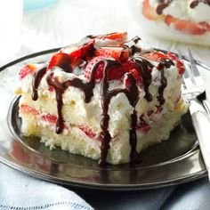 a piece of cake with strawberries and chocolate drizzled on top