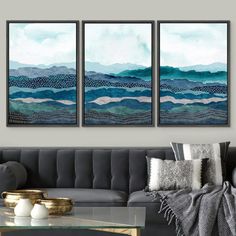 three paintings on the wall in a living room