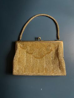 1920s-era Classic Gatsby bag.   Width: 1" Length: 7.5"  Height: 5.5"  Condition: Good vintage condition. Small yellow stains inside.  PLEASE READ POLICIES BEFORE PURCHASE! Item Quality: Please keep in mind that most vintage items are previously owned and have been used or displayed for the past 20-200 years and some aging can be expected. Also due to their often personalized or hand crafted nature, the manufacturer or artist may unintentionally produce imperfections in the product which often ma Vintage Rectangular Evening Bag, Vintage Rectangular Evening Bag For Party, Vintage Rectangular Formal Evening Bag, Vintage Rectangular Evening Bag For Formal Occasions, Mid-century Gold Evening Bag, Retro Gold Evening Bag, Vintage Evening Bag For Vintage Events, Vintage Evening Bag For Events, Gold Vintage Formal Evening Bag