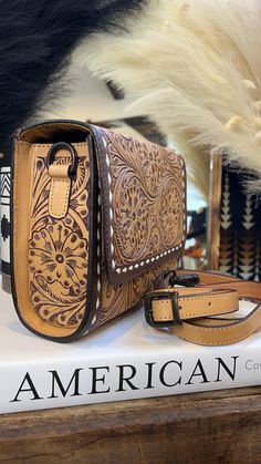 a brown and black purse sitting on top of a book