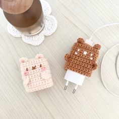 two small crocheted animal plugs sitting next to each other on a table