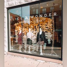 a store front window with mannequins and hats on display in the windows