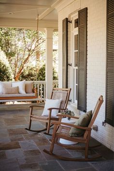 two rocking chairs sitting on the front porch