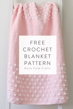 a pink and white blanket hanging on the wall with text overlay that reads free crochet blanket pattern daisy farm crafts