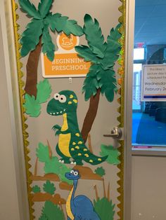 a door decorated with dinosaurs and palm trees for the beginning of pre school year's