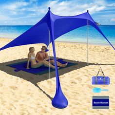 two people sitting under a blue tent on the beach