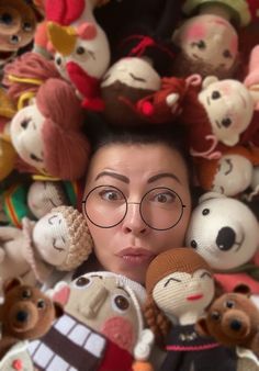 a woman with glasses is surrounded by stuffed animals and teddy bear heads on her head