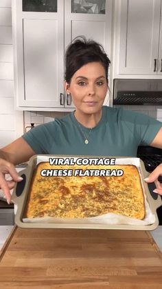 a woman is holding up a large pizza in the kitchen with words on it that read, virtual cottage cheese flatbread