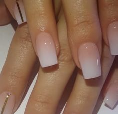 a woman's nails with white and pink ombrettas on top of them