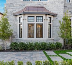 a white brick house with an arched window and tiled walkway leading to the front door