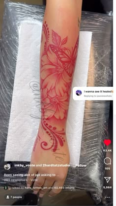 a woman's arm with red flowers on it