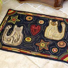 a rug with cats and stars on it in the middle of a floor next to a table