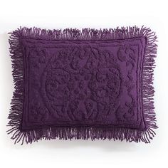 a purple decorative pillow with fringes on the bottom and an intricate design in the middle