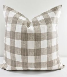 a gray and white checkered pillow on a white background