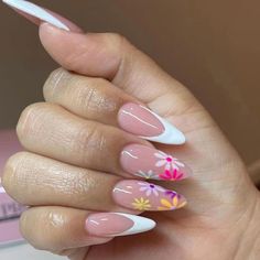 a woman's hand with pink and white flowers painted on her nail polishes