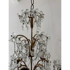 a chandelier hanging from the ceiling with lots of crystal beads on it's arms