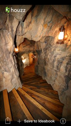 a long wooden staircase leading up to a cave like area with lights on it's sides