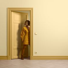 a woman is standing in an open door and looking into the room with her back to the camera