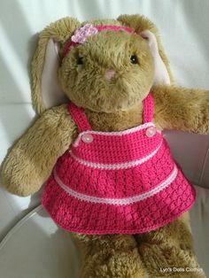 a brown stuffed animal wearing a pink dress