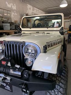 an old jeep is parked in a garage