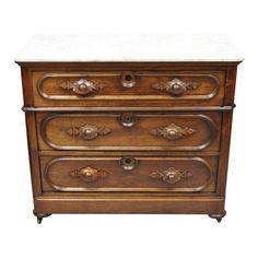 an old wooden dresser with marble top