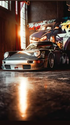 a silver sports car parked in front of a graffiti covered wall