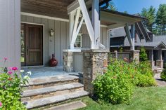 a house with stone steps leading up to the front door and flowers in the foreground