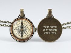 a compass necklace with an engraved message on the front, and a chain attached to it