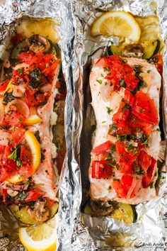 two fish fillets covered in tomatoes, lemons and parsley on aluminum foil