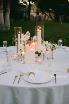 the table is set with candles and flowers for an elegant wedding reception or special event