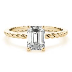 an emerald - cut diamond ring with twisted shans on the band, set in 18k yellow gold