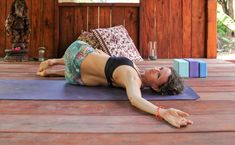 a woman is doing yoga on a mat in front of a wooden wall and floor