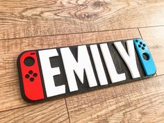 a nintendo wii game controller name plate on a wooden floor with the word family spelled in white and red