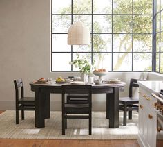 a kitchen with a table and chairs in front of an open window that looks out onto the outdoors