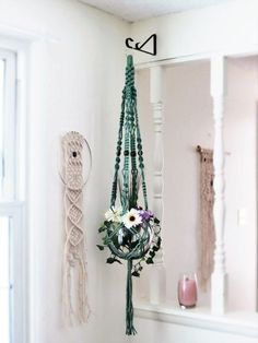 there is a flower arrangement hanging on the wall next to a mirror and other items