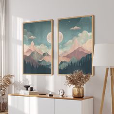 two paintings hanging on the wall above a dresser