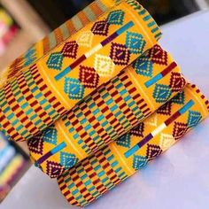 Kente fabric, Handwoven from Ghana. Kente yard is not the same as African fabric/ankara . This woven top-notch quality kente is not measured like the normal African fabric/Ankara. The Kente strips are joined together to make 2 yards for a piece in three to make 6 yards. The weavers weave it up to 14 or 15 stripes and join all the stripes to make the full 12 yards kente but when they weave it in small stripes it's either 17 or 18 stripes to make the full 12 yards kente. This is purely handwoven k Kente Fabric, Costume Africain, Africa Dress, African Wear Dresses, Kente Cloth, African Men, African Wear, Woven Top, African Fabric