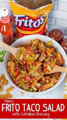 a white bowl filled with taco salad next to chips and ketchup bottles