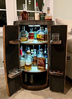 an open cabinet filled with liquor bottles and glasses