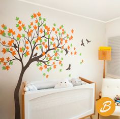 a baby's room with a tree painted on the wall