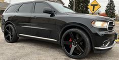 a black dodge suv parked in front of a house