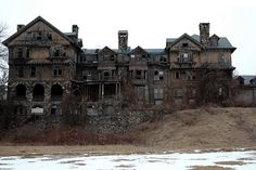 an old abandoned house sitting on top of a hill