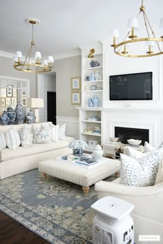 a living room filled with furniture and a flat screen tv mounted on the wall above a fireplace