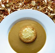 a white bowl filled with soup and a biscuit