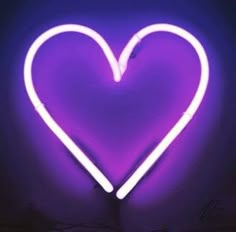 a purple heart shaped neon sign in the dark with no light on it's sides