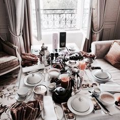 a dining table is set with dishes and silverware for an elegant dinner party in the living room