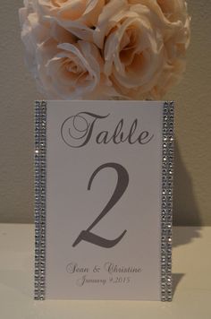 a table number holder with roses in it