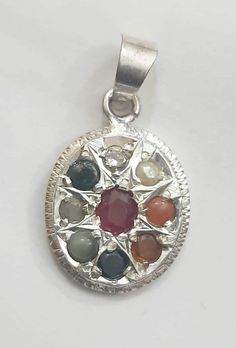 Navaratna is a combination of nine gemstones (Ruby, White Topaz, Iolite, Citrine, Emerald, Red Coral, Pearl, Cats eye and Hessonite Garnet) worn in a single ornament. What is the benefits of Navaratna Pendant ? It can avoid negative impulses and getting positive energy. Navaratna is providing good healthy conditions and balanced emotions. While wearing these auspicious stones, people will get concentration in making exact decisions in life, getting peace of mind and wealth. Weight- 3 Gram Length Spiritual Multi-stone Oval Gemstones, Multicolor Round Gemstones With Stone Setting, Silver Gemstone Beads For Jewelry Making, Silver Stones For Jewelry Making, Silver Beads, Gems And Cabochons For Jewelry Making, Spiritual Silver Gemstone With Oval Pendant, Spiritual Silver Oval Pendant Gemstone, Spiritual Silver Birthstone Gemstones, Multicolor Round Sterling Silver Gemstones